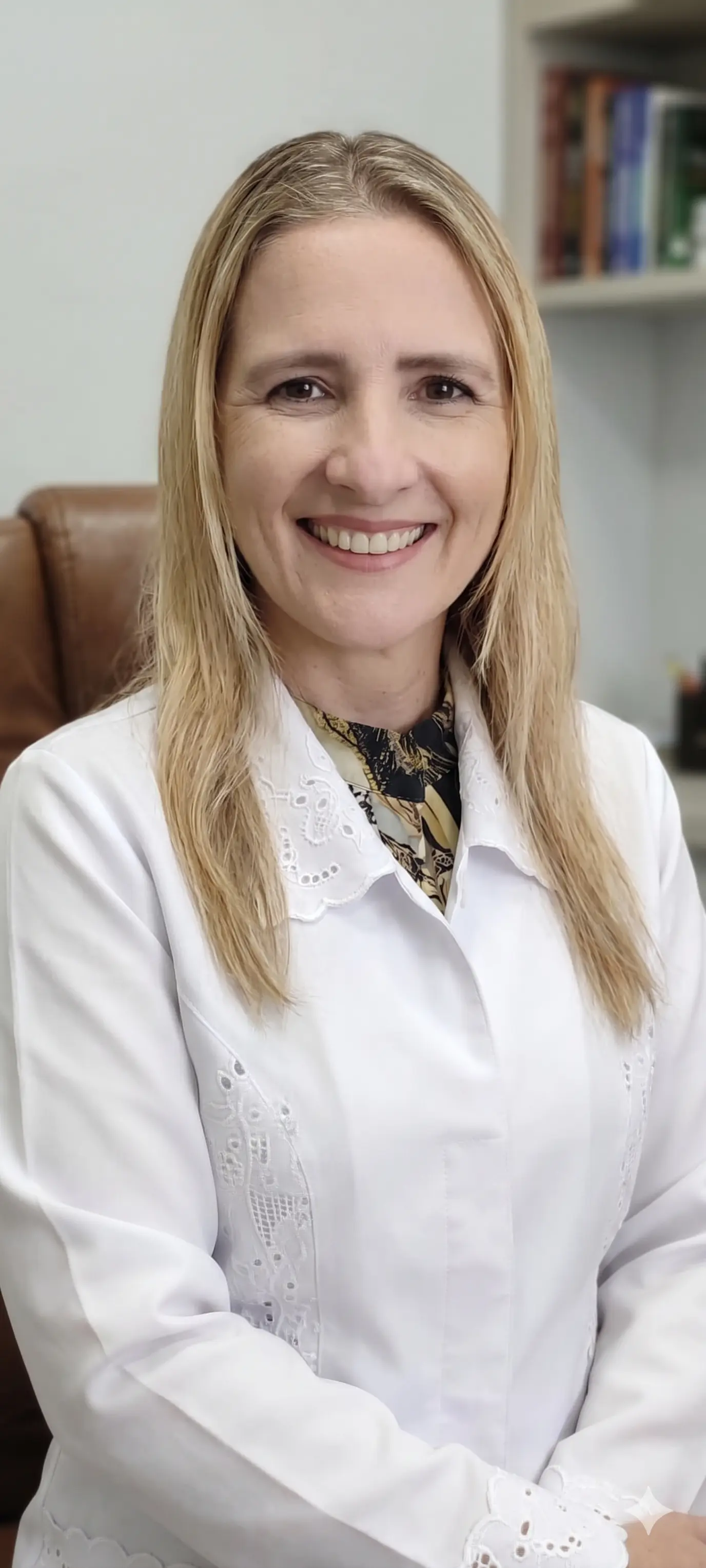 Dra. Juliana Dias, médica geriatra em Belo Horizonte, sorrindo de jaleco branco